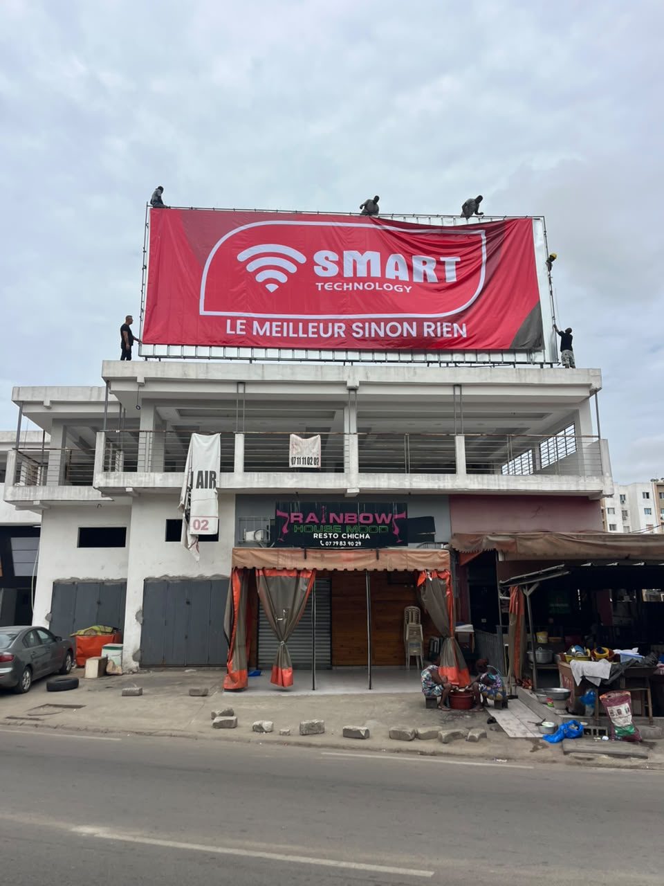 Installation d'une bâche publicitaire grand format pour Smart Technology par FADI DESIGN à Abidjan